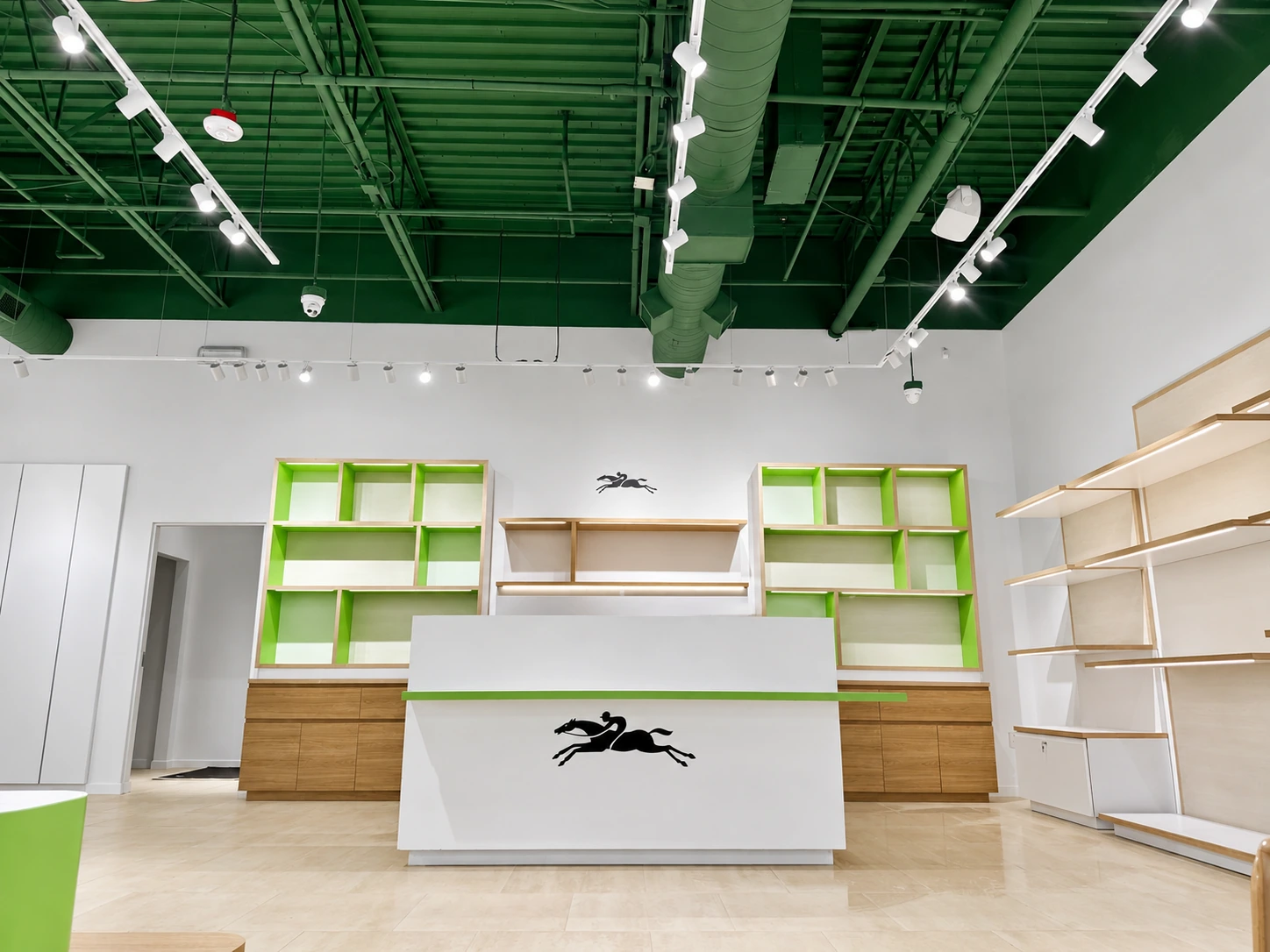 Retail checkout with green ceiling, white track lights and illuminated shelving