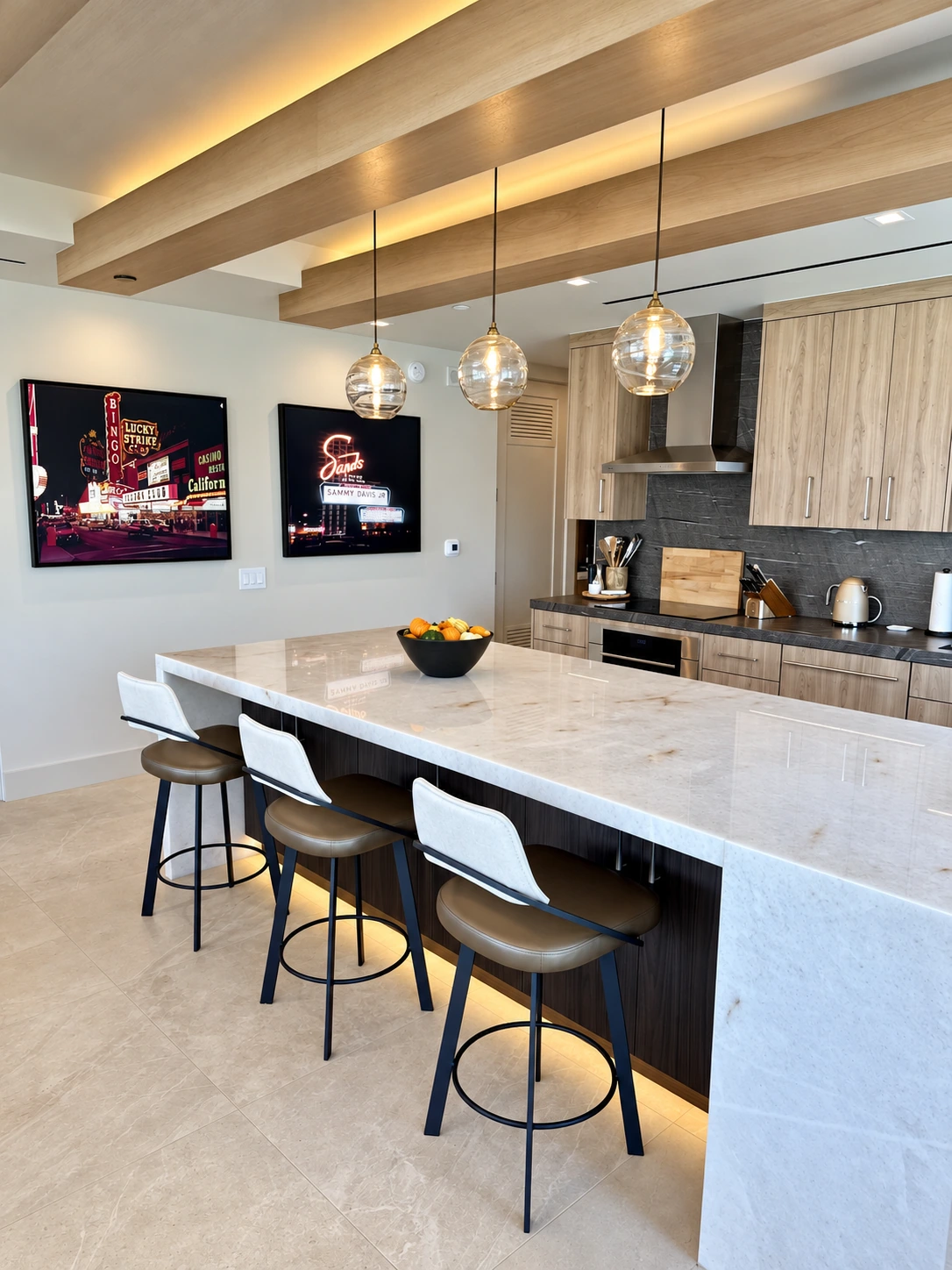 High-rise kitchen with glass pendants, cove lighting and an illuminated island